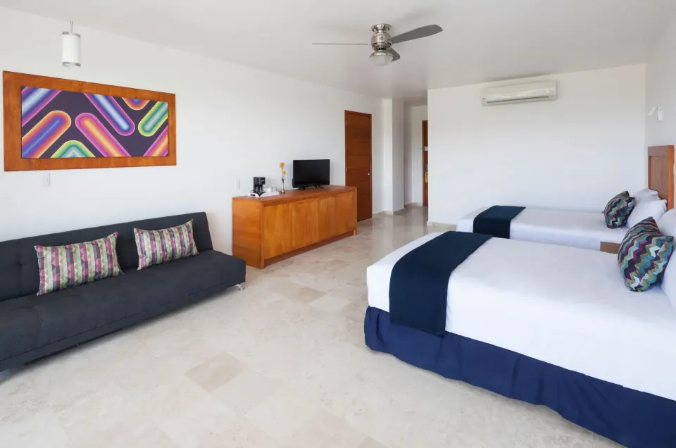 Deluxe Room with two beds, sofa, wood cabinet, and wall art at Villa Varadero.