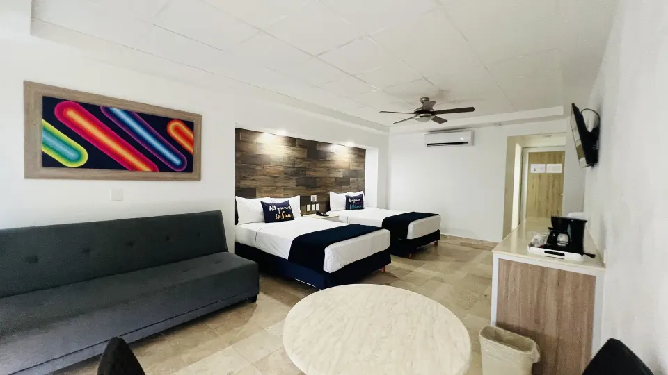 Junior room with two beds, sofa, TV, and coffee station at Villa Varadero.