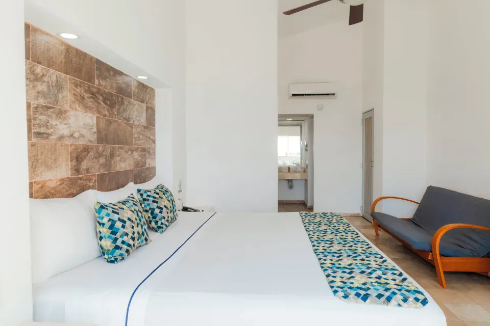 Superior Sea View room with king bed, sofa, and bathroom doorway at Villa Varadero.