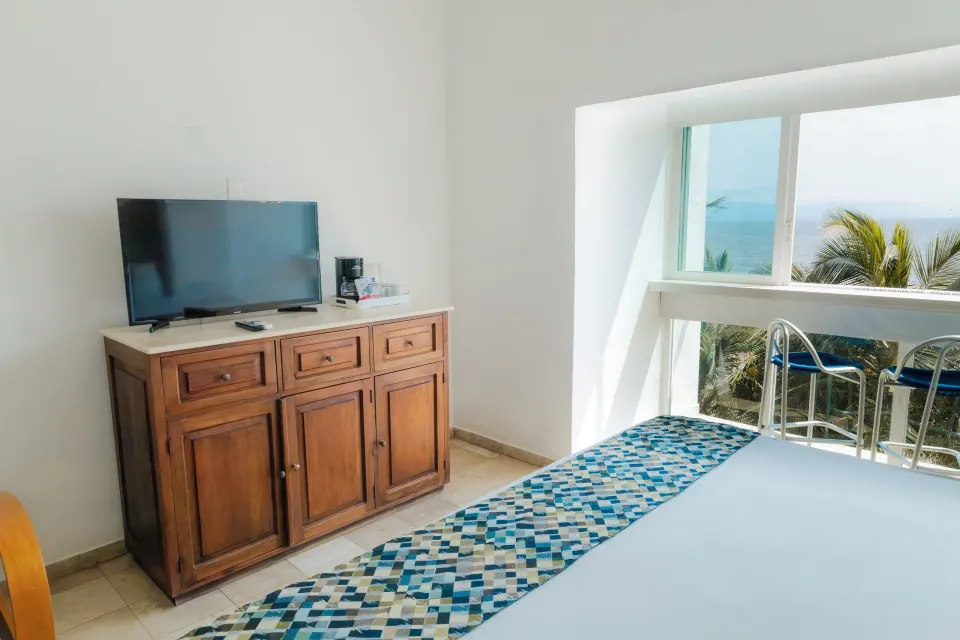 Superior Sea View room with king bed, TV cabinet, and ocean-facing window at Villa Varadero.