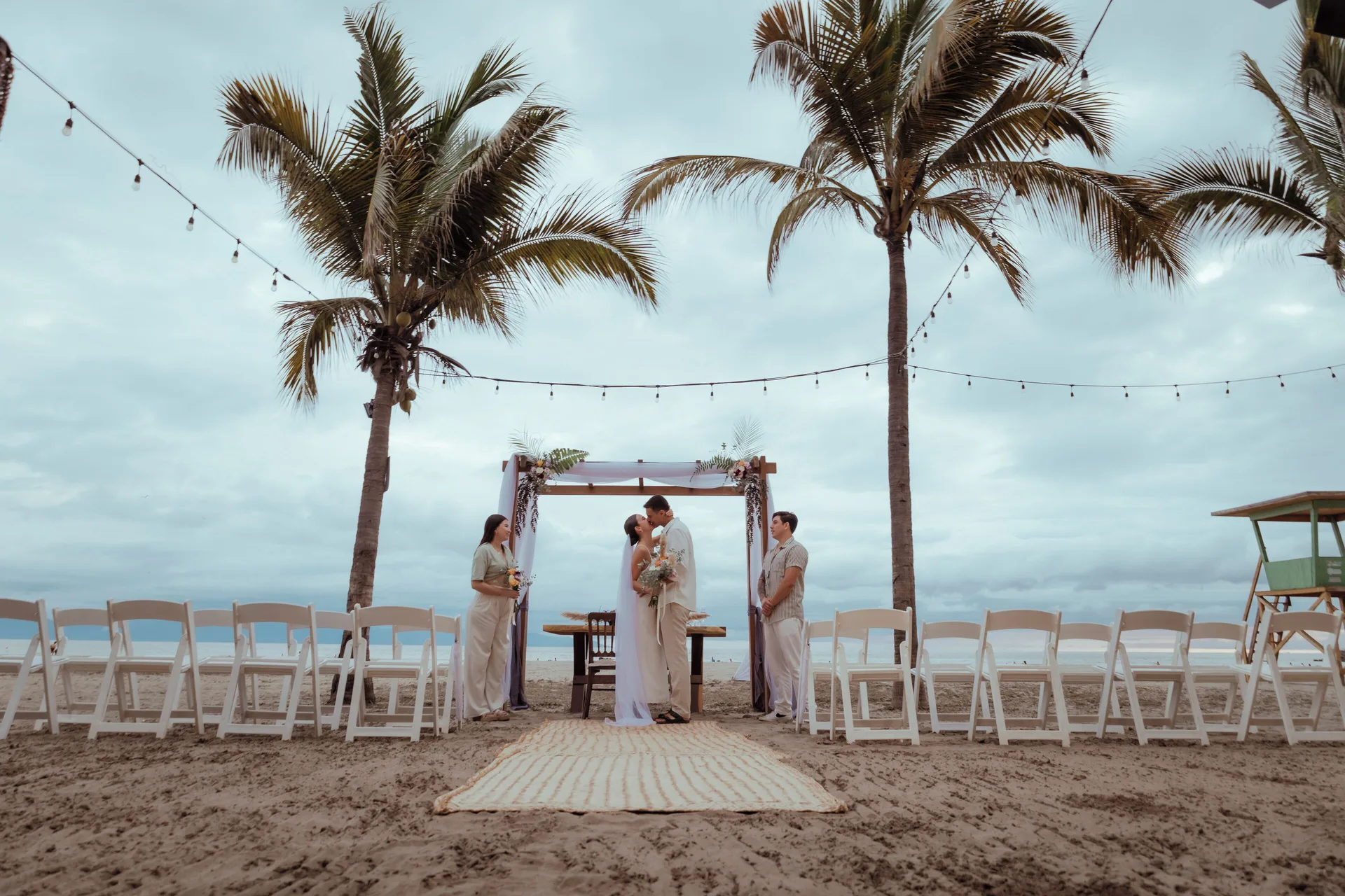 Beach wedding ceremony between palm trees with white chairs at Villa Varadero.