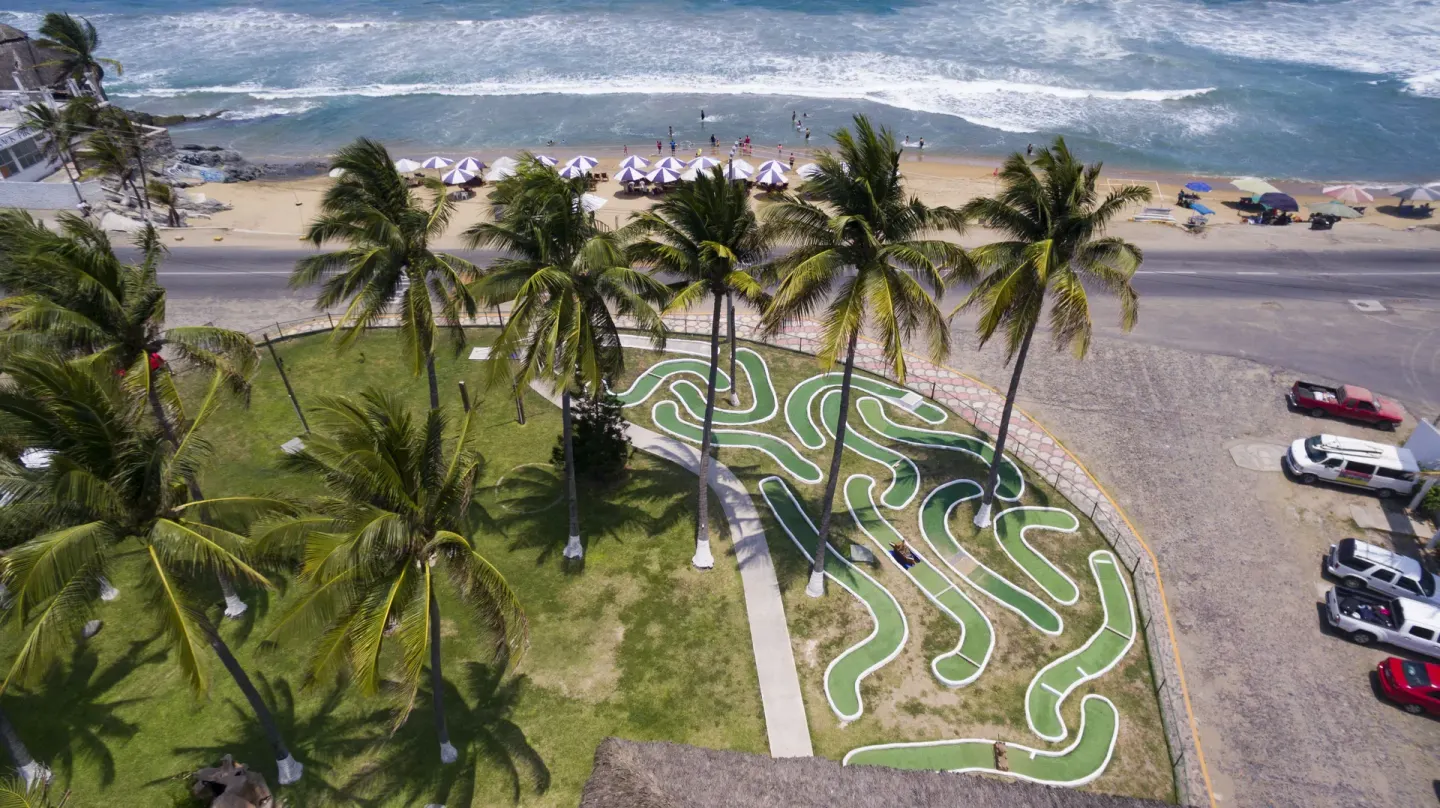 Aerial view of palms, garden paths, road, and beach at Vista Playa de Oro Manzanillo.