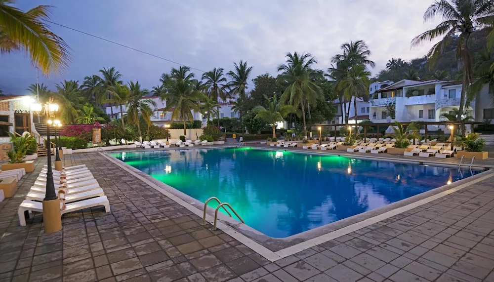 Large evening pool with loungers and palm trees at Vista Playa de Oro Manzanillo.