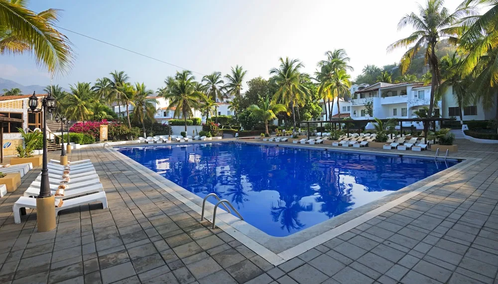 Large rectangular pool with loungers and palms at Vista Playa de Oro Manzanillo.