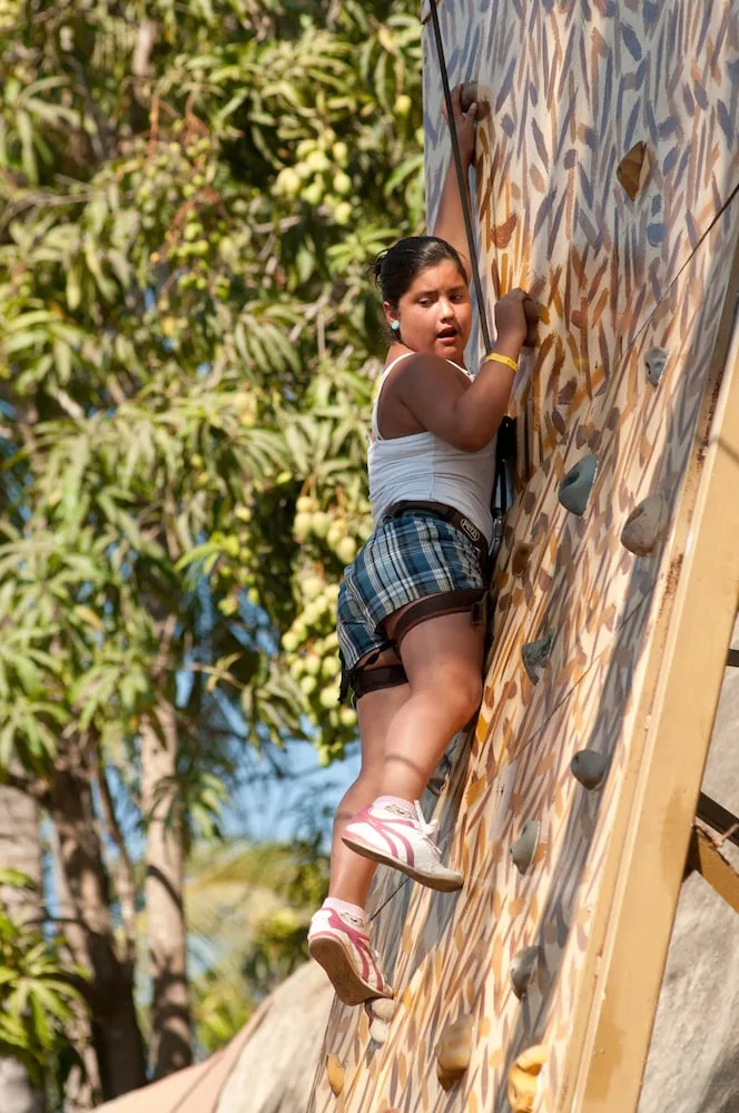 Child climbing an outdoor rock wall at Vista Playa de Oro Manzanillo.