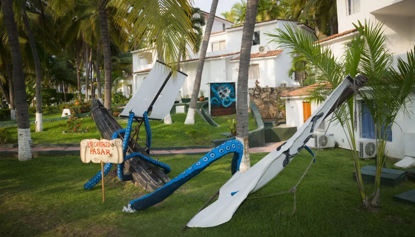 Pirate-themed lawn display among palms and white buildings at Vista Playa de Oro Manzanillo.