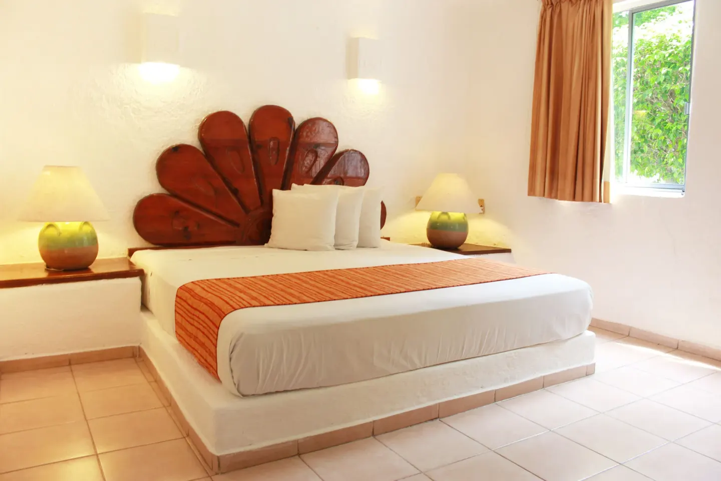 Standard Room king bed with shell headboard and window at Vista Playa de Oro Manzanillo.