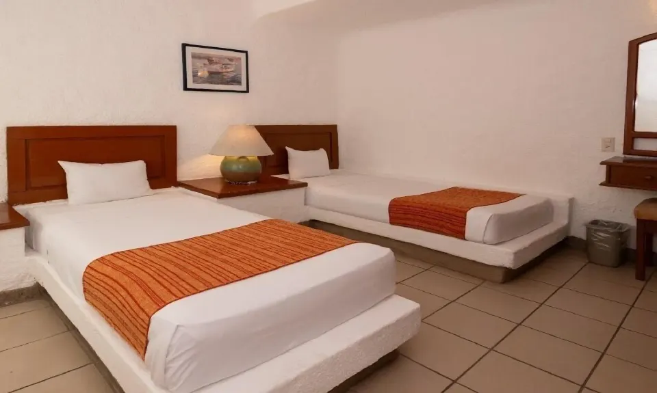 Standard Room with two beds, vanity mirror, and tile floor at Vista Playa de Oro Manzanillo.