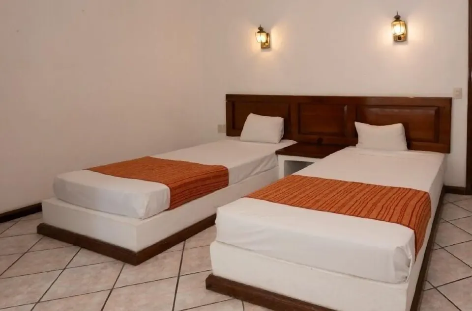 Standard Room with two twin beds and wall lanterns at Vista Playa de Oro Manzanillo.