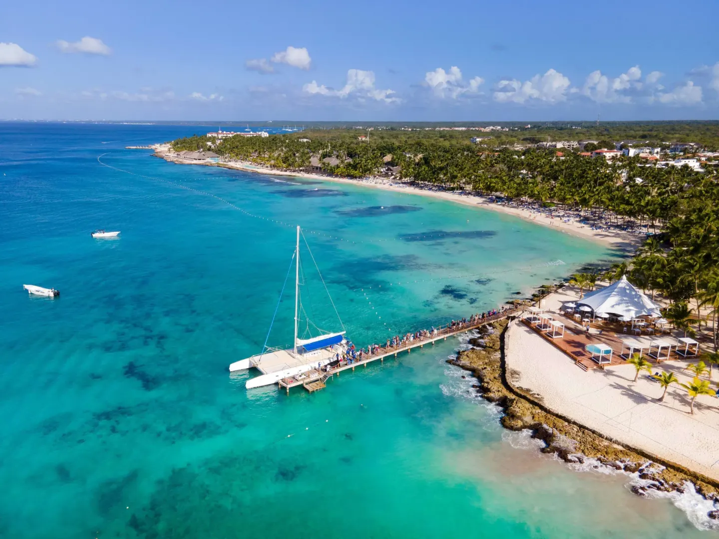 A catamaran is docked at the pier beside the beach at Viva Dominicus Palace.