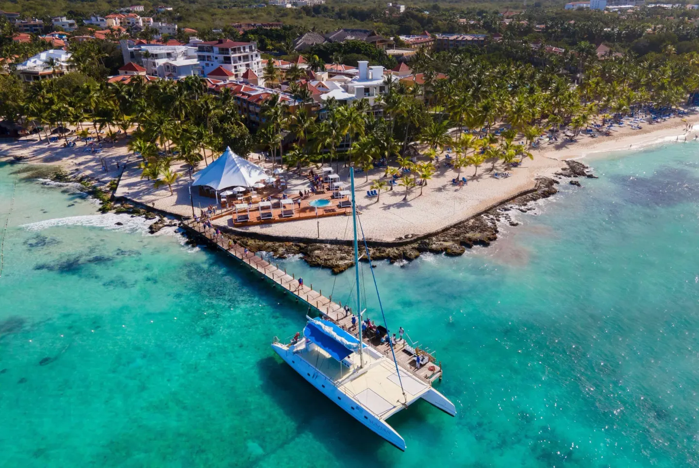 Catamaran by the pier and palm-lined beach at Viva Dominicus Palace.