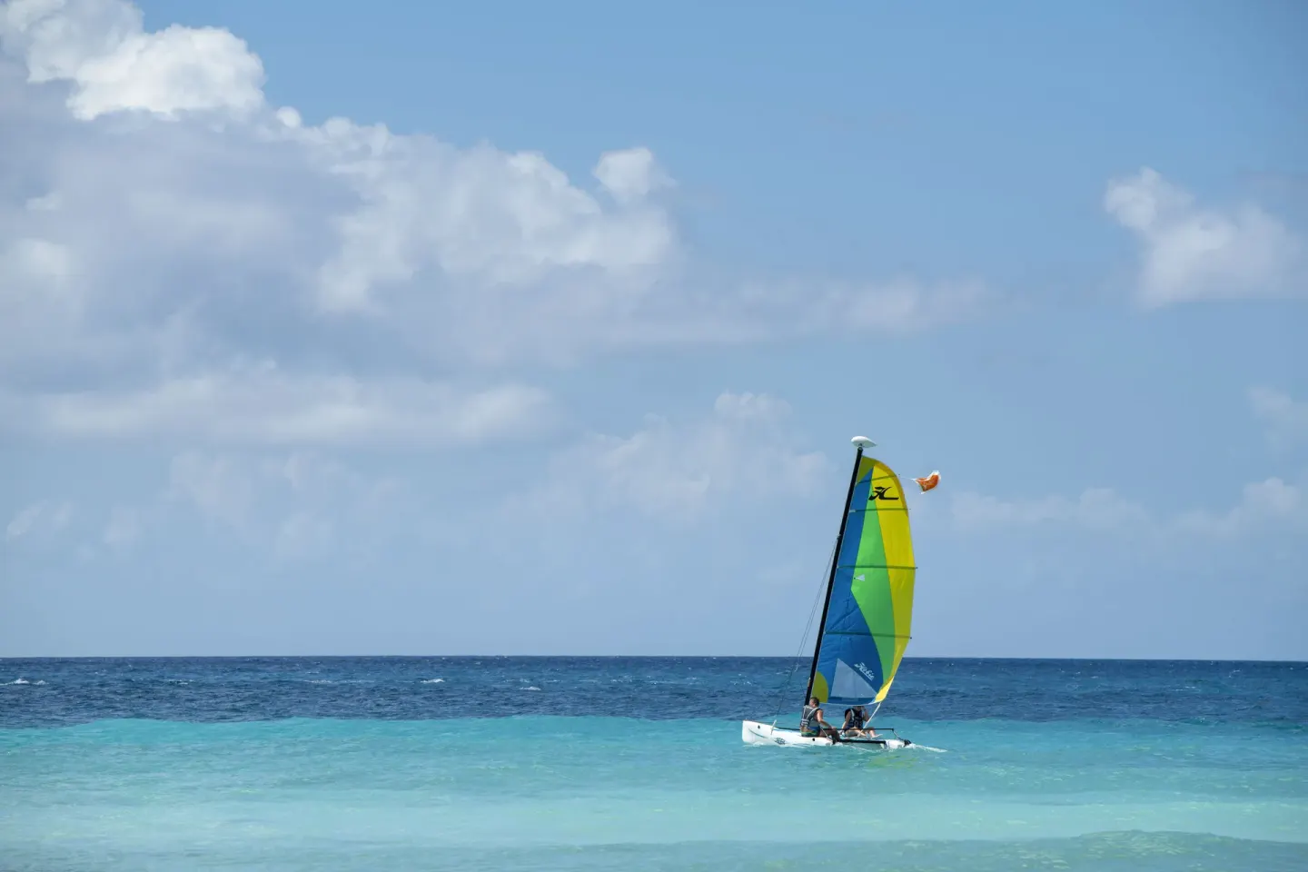 A colorful catamaran sails on turquoise water at Viva Dominicus Palace.