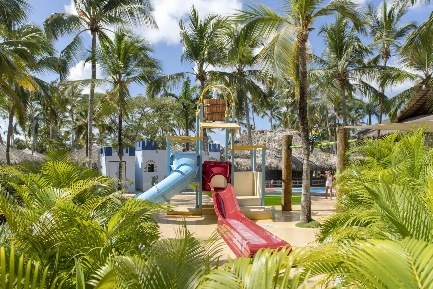 A children’s water play area with slides and palms at Viva Dominicus Palace.