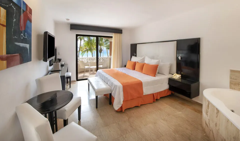 Guest room with king bed, balcony ocean view, and tub at Viva Dominicus Palace.