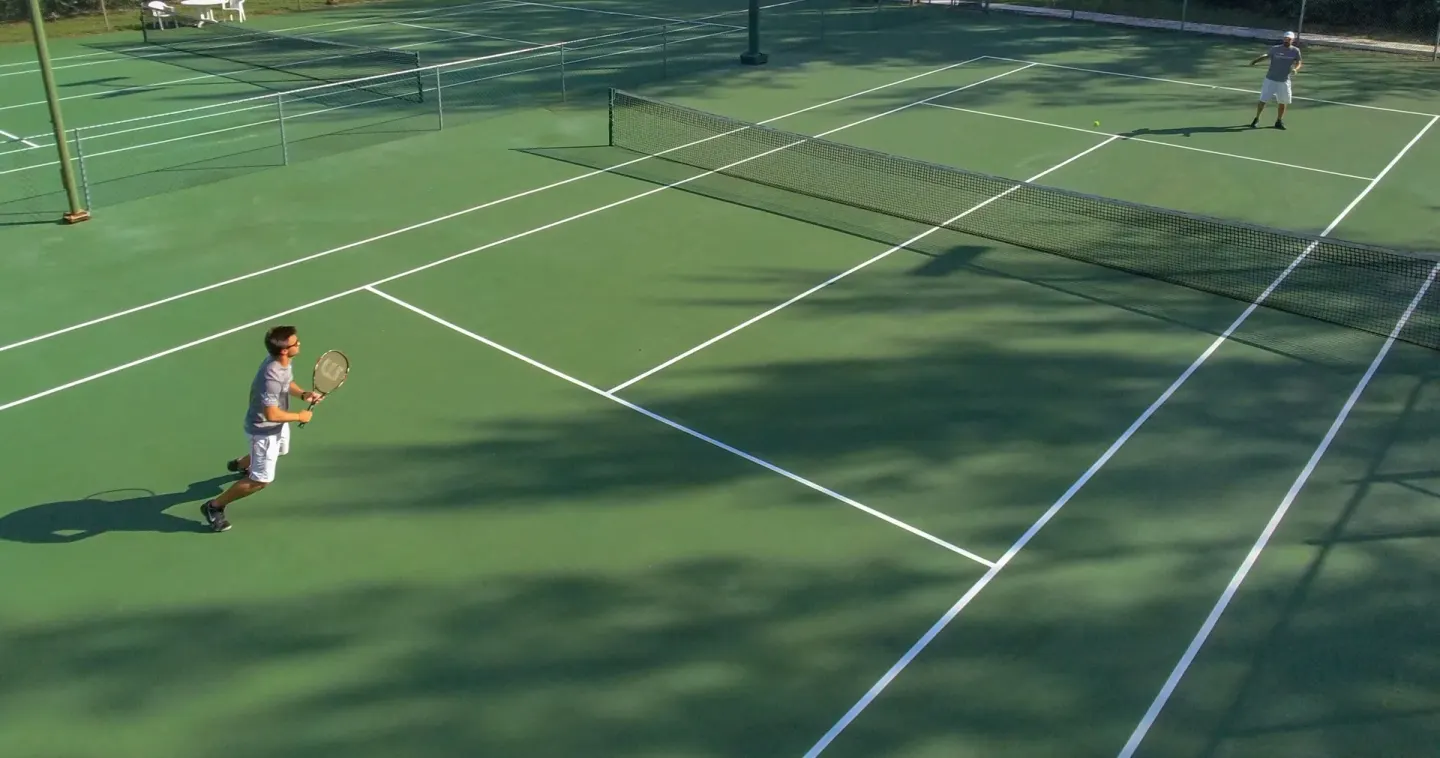 Guests play tennis on green outdoor courts at Viva Dominicus Palace.