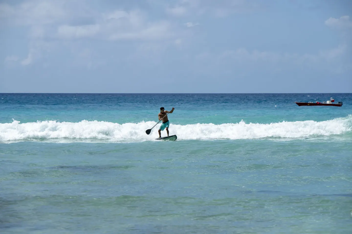 A paddleboarder rides small waves offshore at Viva Dominicus Palace.