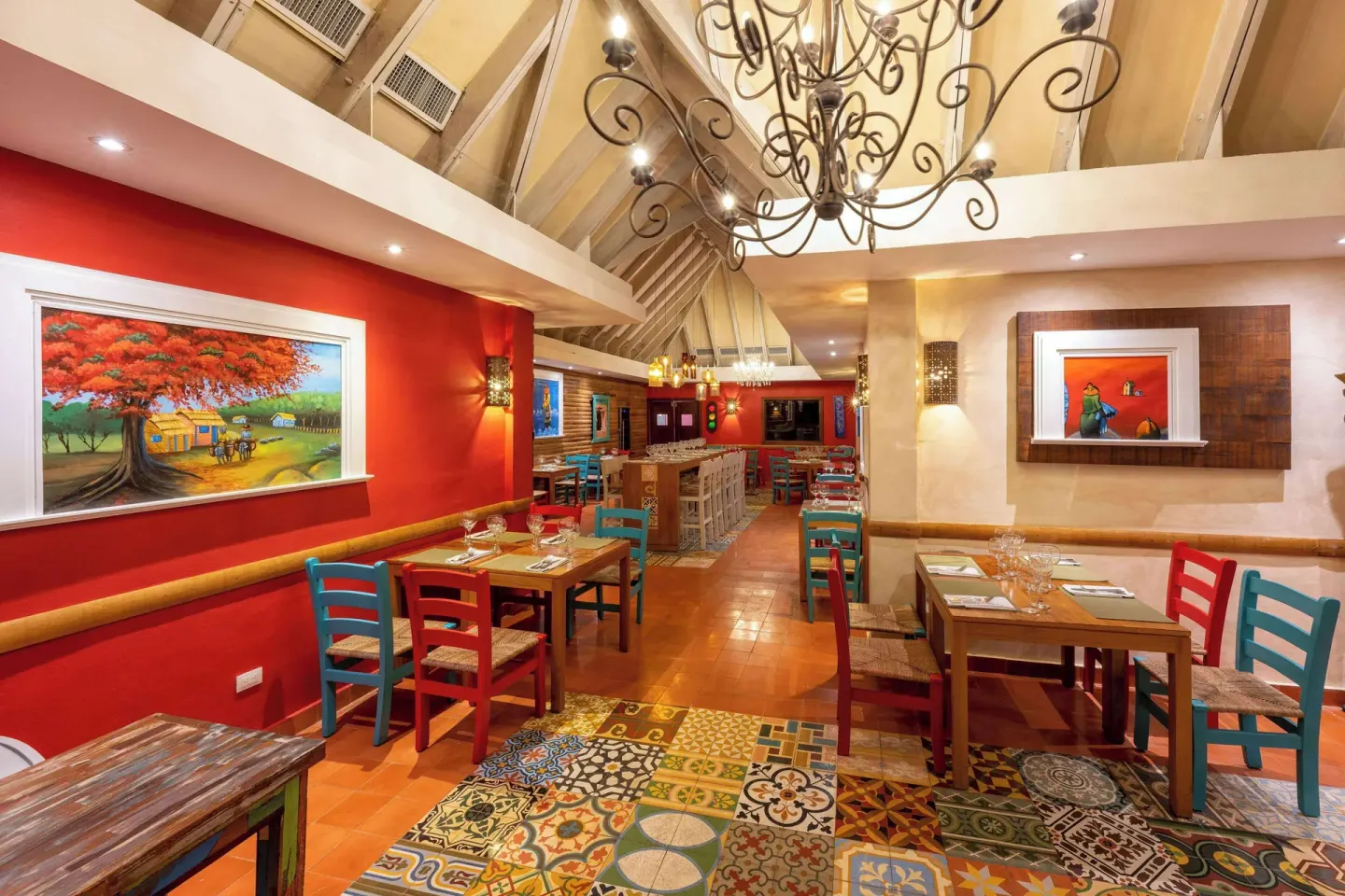 Colorful restaurant interior with painted chairs and artwork at Viva Dominicus Palace.