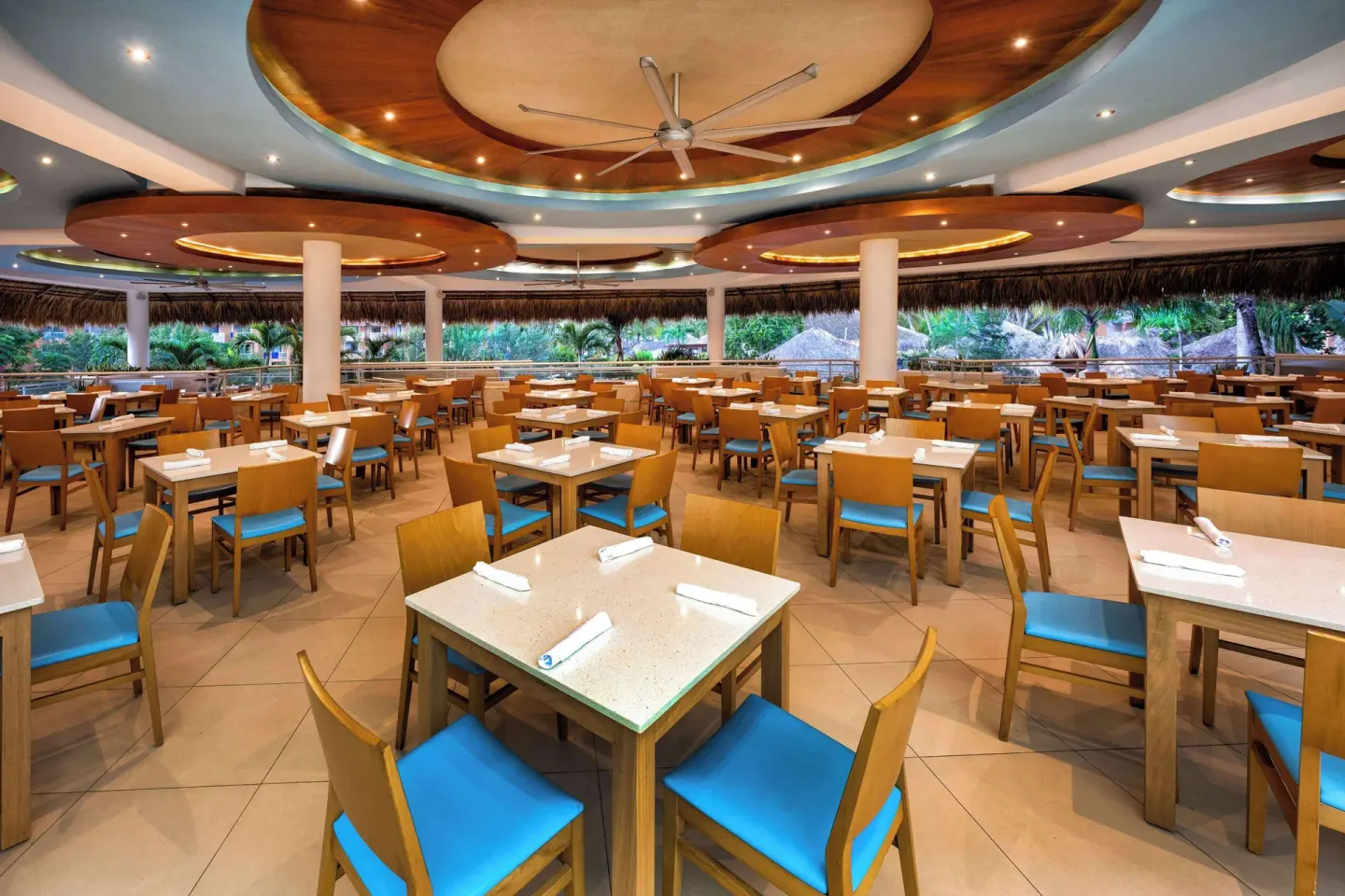 Large open-air buffet dining room with blue chairs at Viva Dominicus Palace.