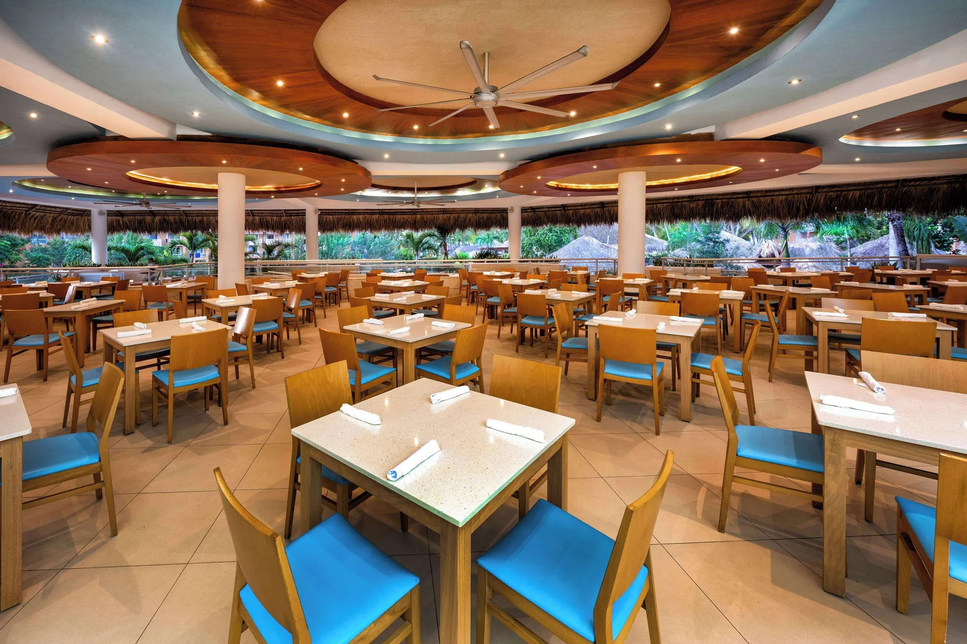 Large open-air buffet dining room with blue chairs at Viva Dominicus Palace.