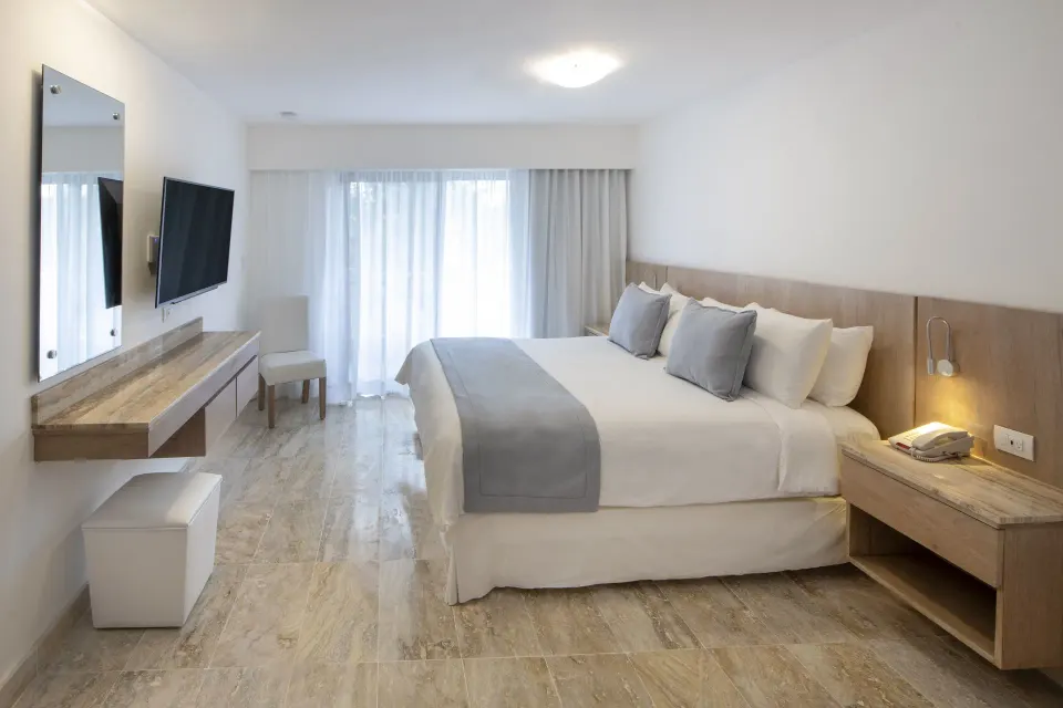 Superior Plus king guest room with TV and vanity at Viva Dominicus Palace.