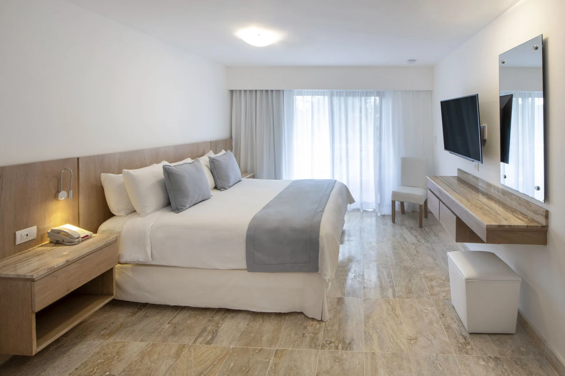 Superior Plus king room with bedside table and wall TV at Viva Dominicus Palace.