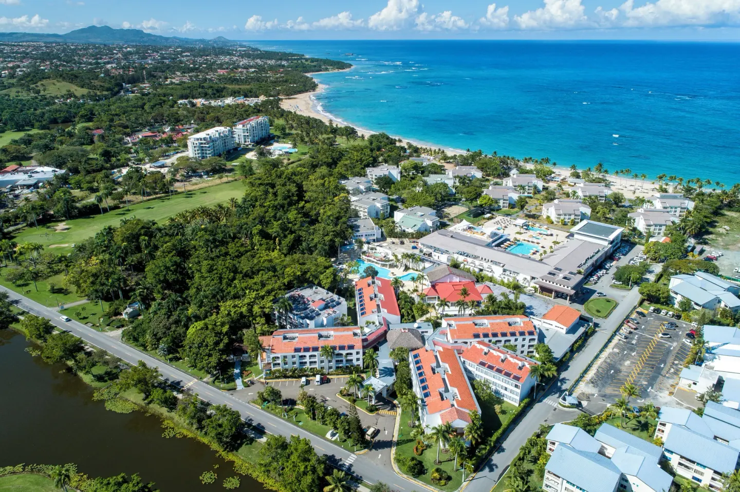 An aerial view shows Viva Heavens near the coastline, beach, and blue ocean.