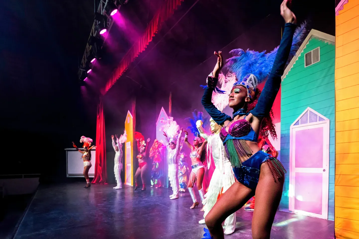 Costumed performers on a brightly lit stage during a show at Viva Heavens.