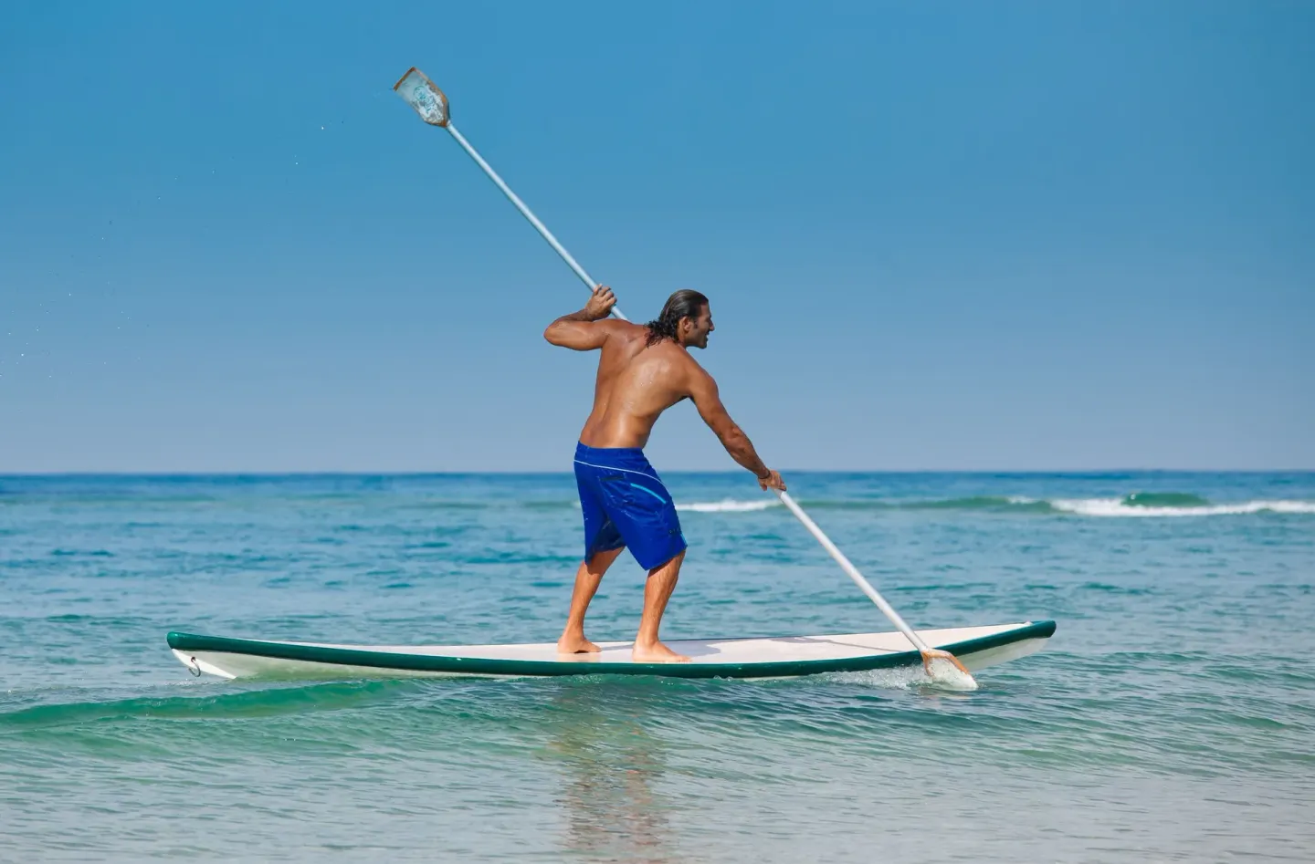 Stand-up paddleboarder on calm ocean water at Viva Heavens.