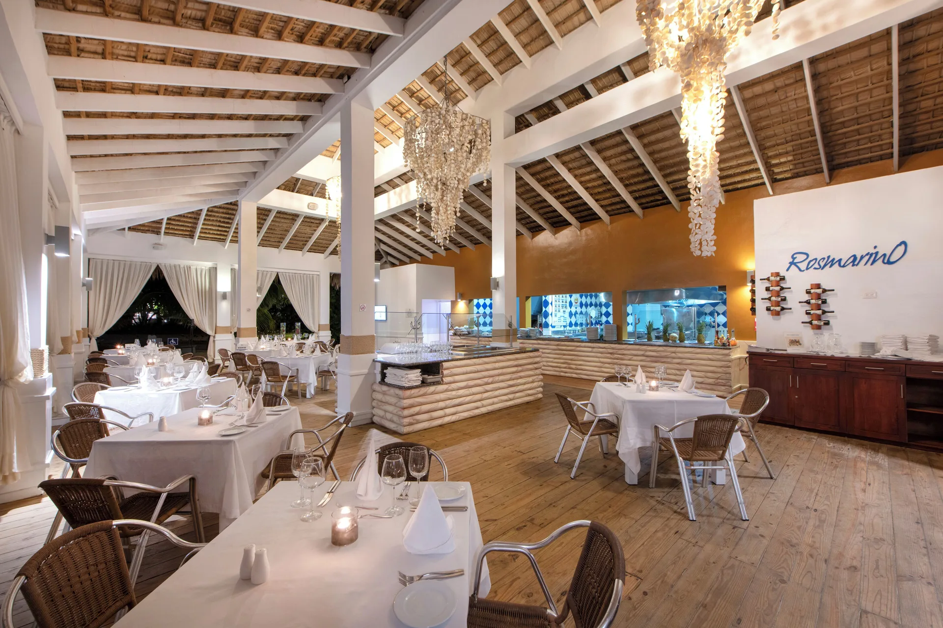 Rosmarino dining room with white tablecloths and chandeliers at Viva Heavens.