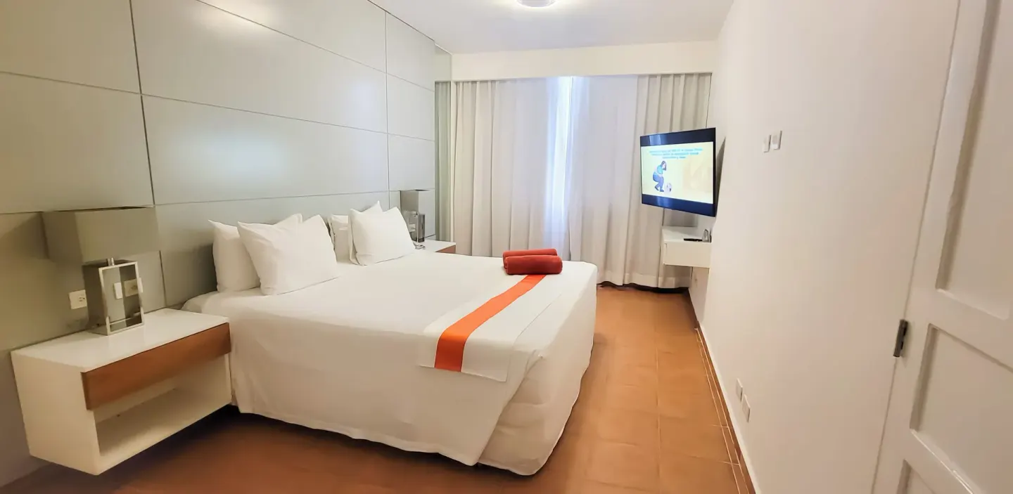 All Together Non-Smoking room with king bed and wall-mounted TV at Viva Heavens.