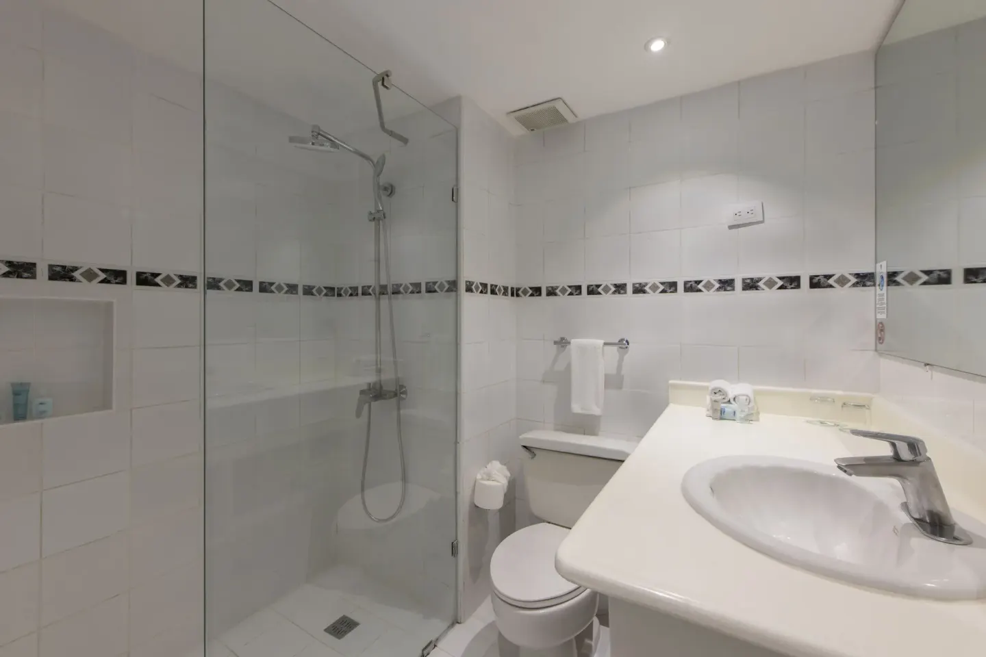 Amnesia 1 Size Bed bathroom at Viva Heavens with glass shower, toilet, sink, and mirror.