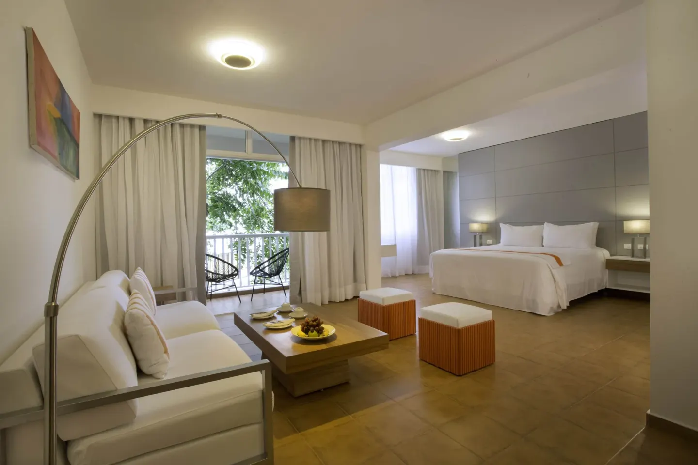 Amnesia 1 Size Bed room at Viva Heavens with a bed, sofa, coffee table, and balcony seating.
