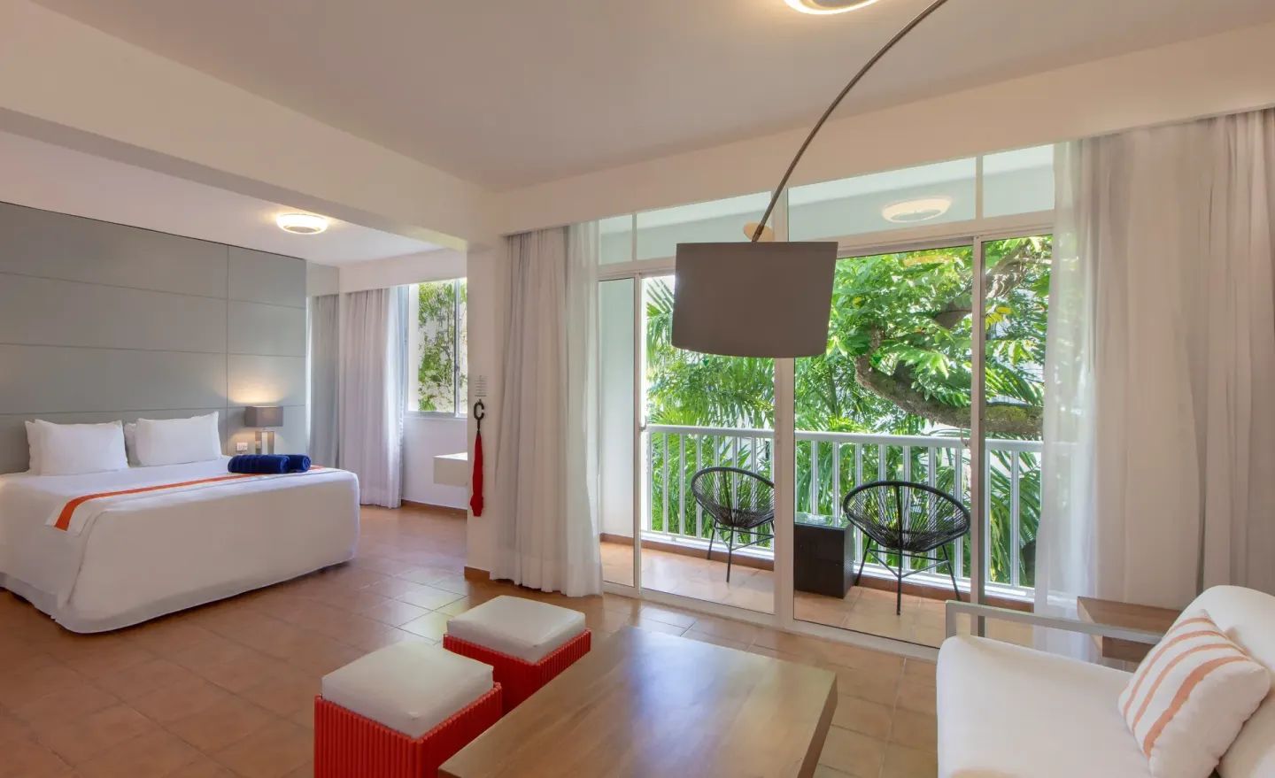 Amnesia 1 Size Bed room at Viva Heavens with a bed, sofa corner, and balcony facing trees.