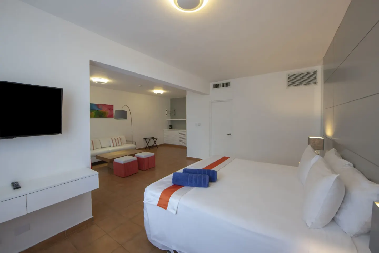 Amnesia 1 Size Bed room at Viva Heavens with a bed, wall TV, lounge area, and kitchenette nook.