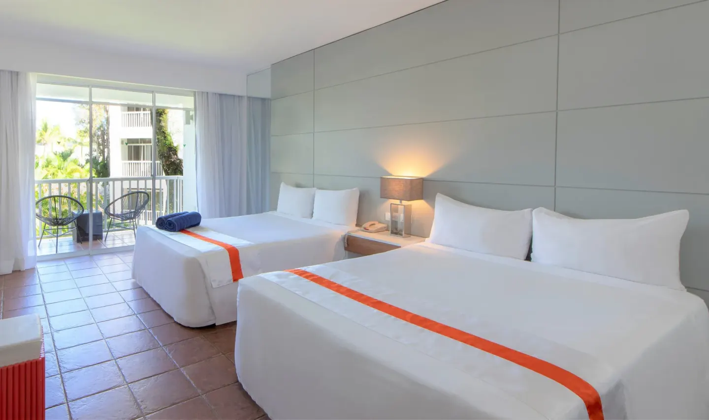 Nirvana room with two size beds, balcony seating, and large glass doors at Viva Heavens.
