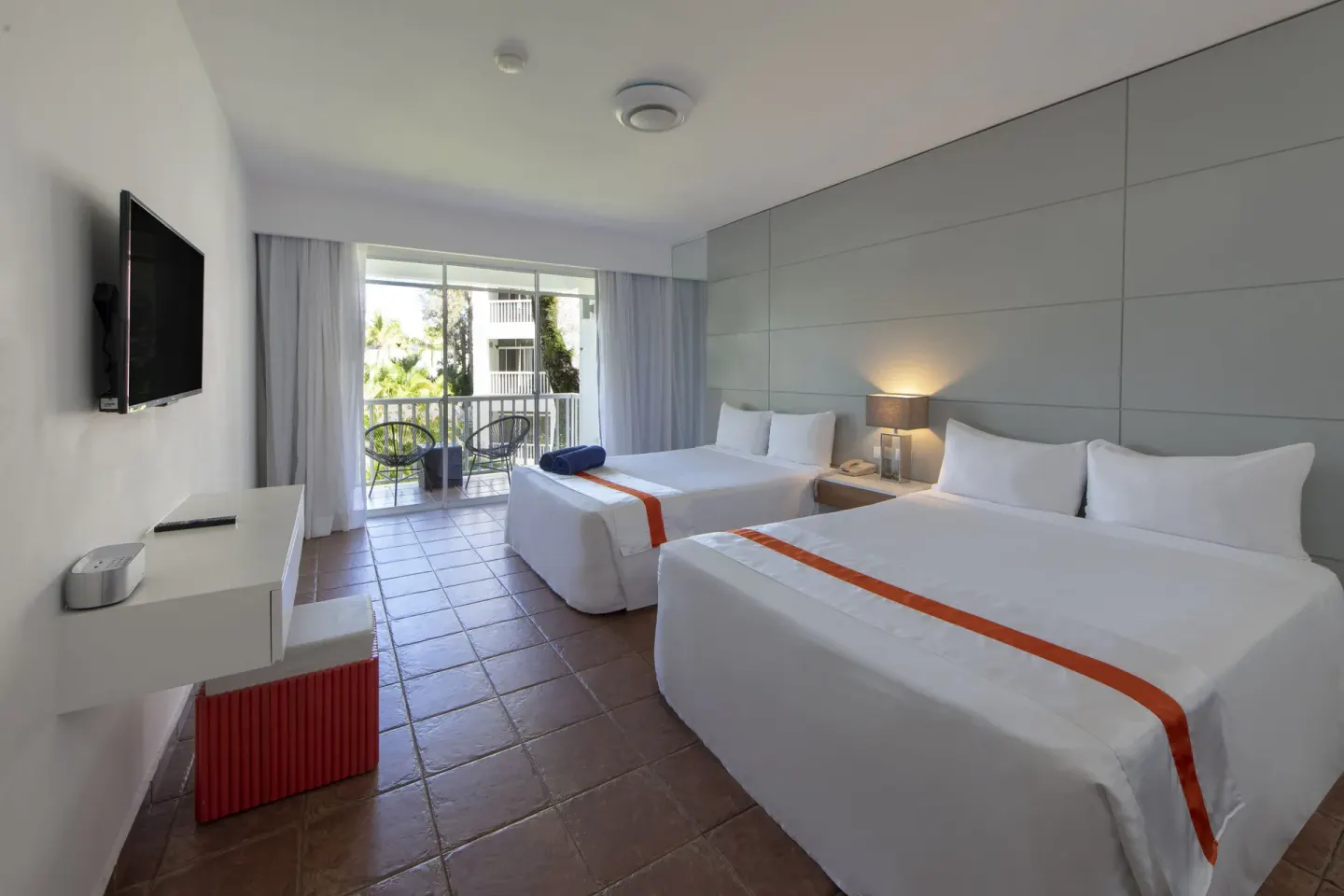 Nirvana room with two size beds, TV, desk, and balcony doors at Viva Heavens.
