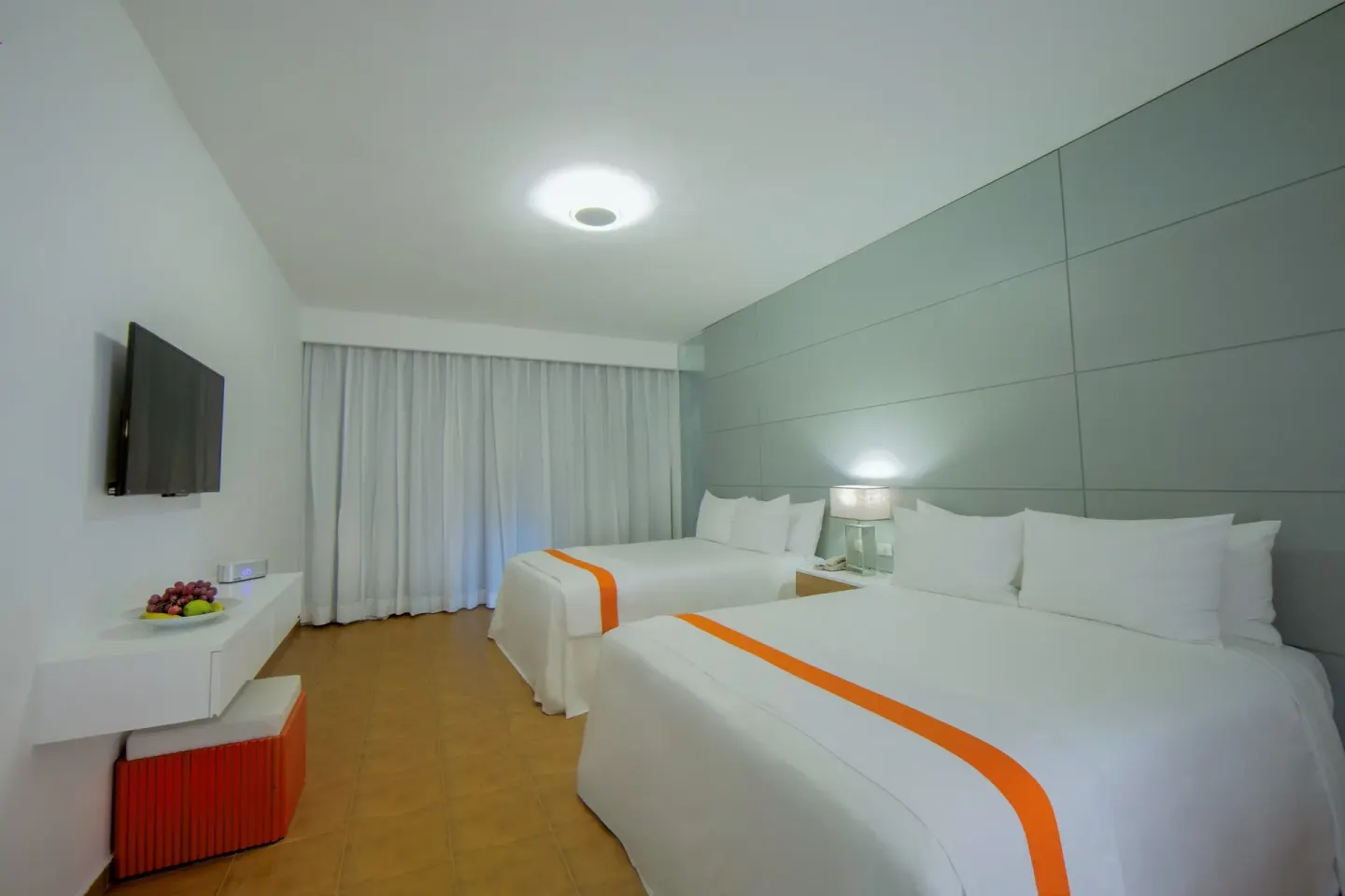 Nirvana room with two size beds, wall TV, desk, and curtains at Viva Heavens.