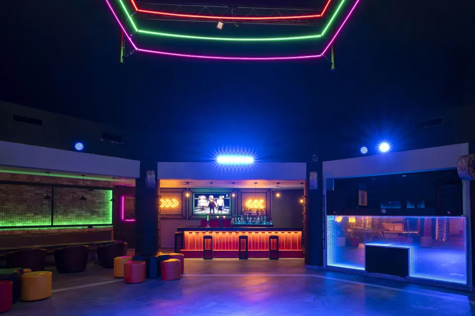 Club interior with illuminated bar and neon accents at Viva Maya.