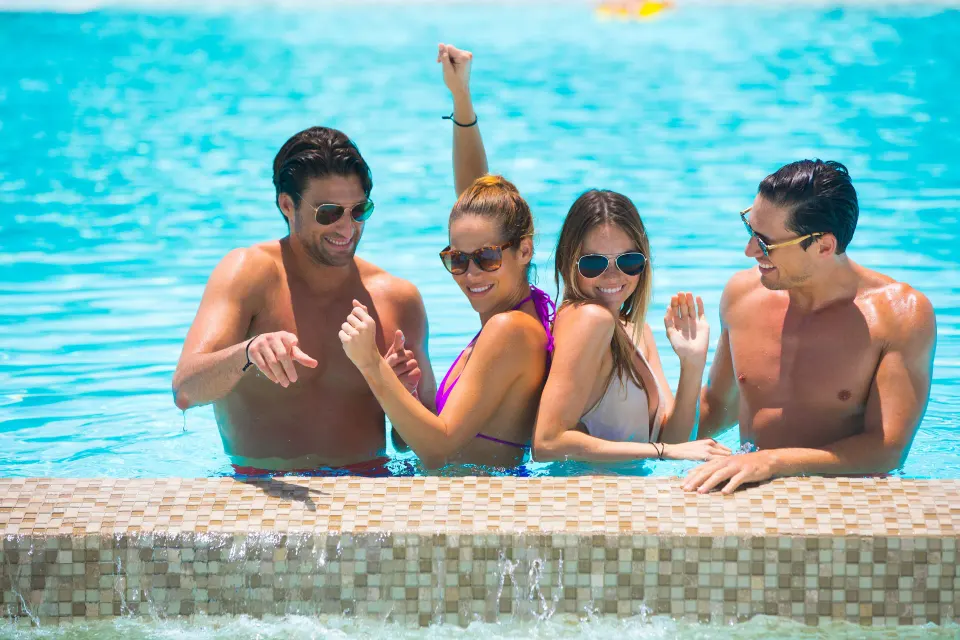 Group of four guests enjoying the resort pool together at Viva Maya