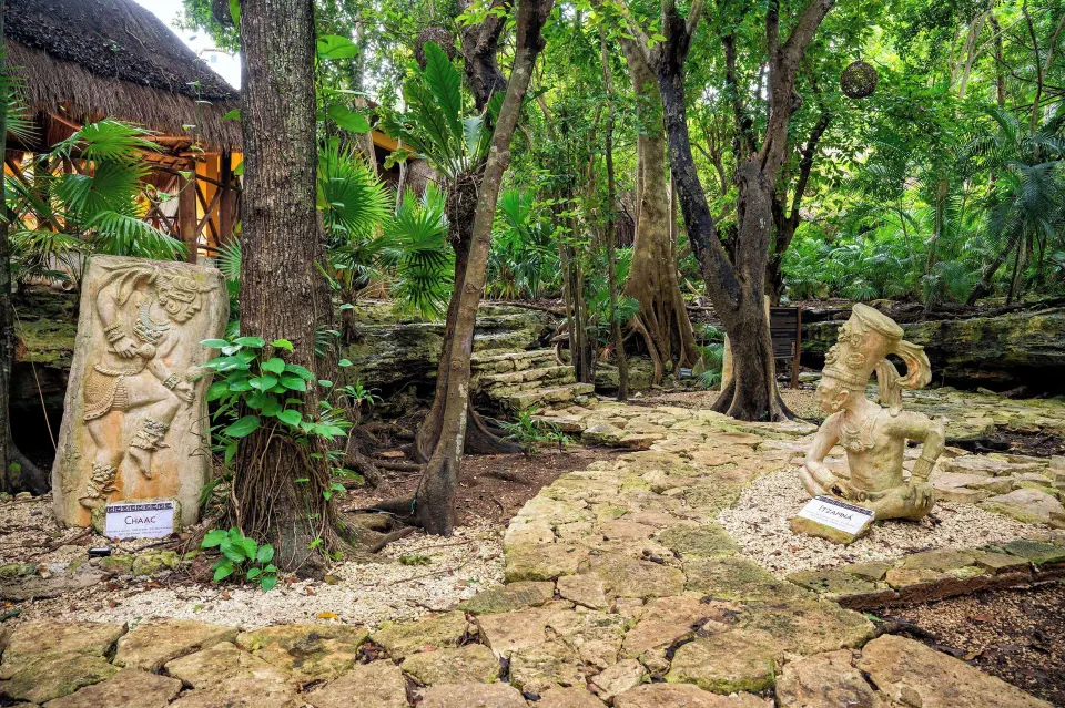 Stone sculptures and shaded jungle path at Viva Maya