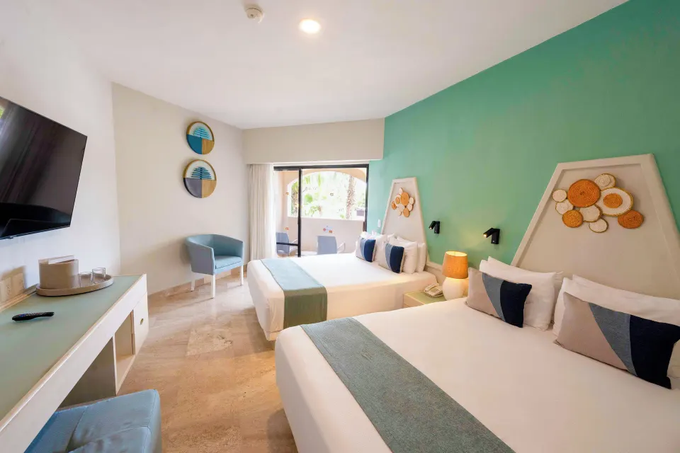 Bright guest room with two beds and sliding patio door at Viva Maya