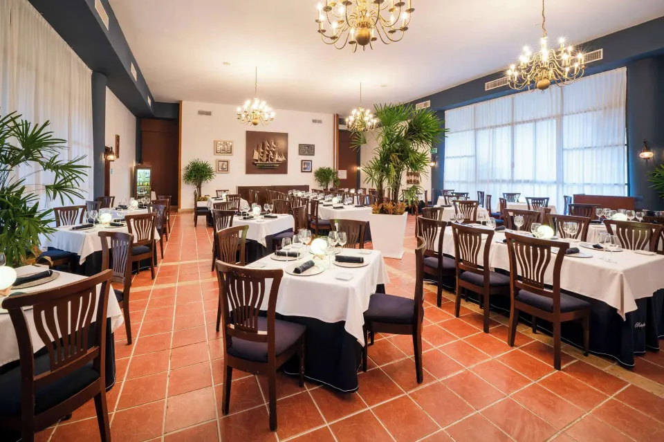 Formal indoor dining room with chandeliers and set tables at Viva Maya