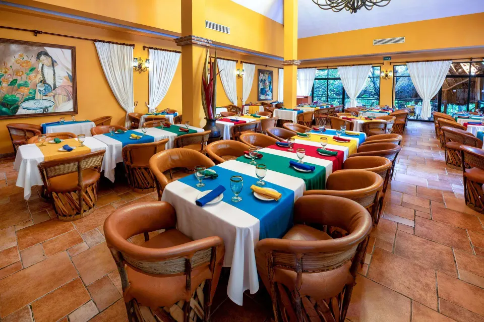 Colorful Mexican-style dining room with round leather chairs at Viva Maya