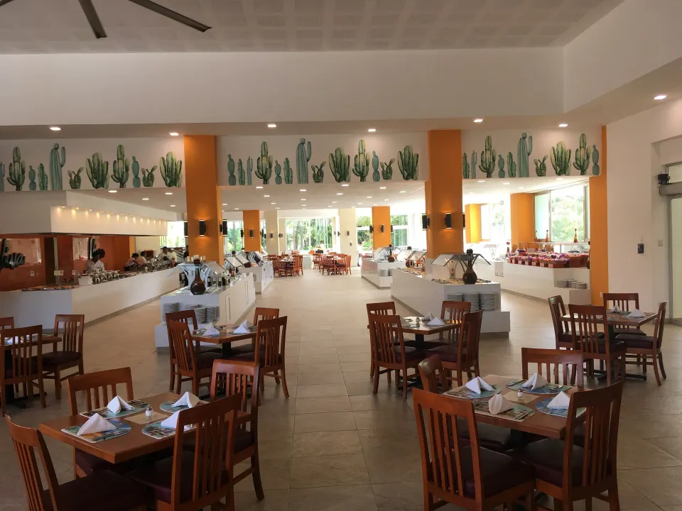 Large bright buffet dining room with cactus mural at Viva Maya