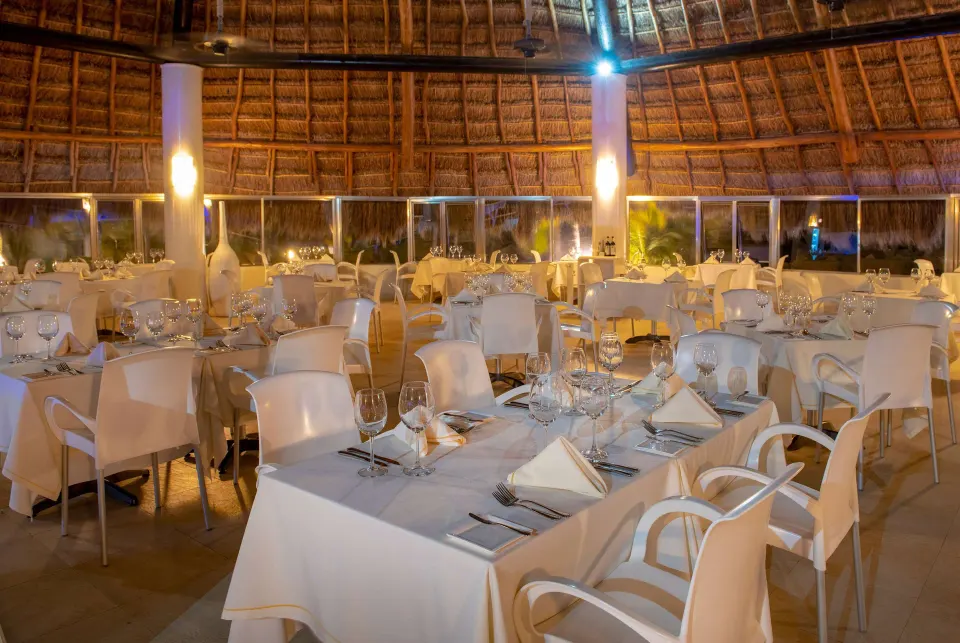 Circular palapa dining room with white-clothed tables at Viva Maya