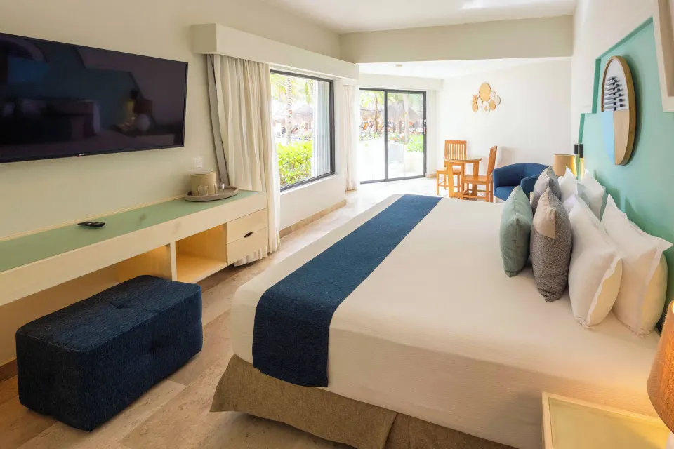 Superior Garden Room king bed viewed toward the TV and balcony at Viva Maya