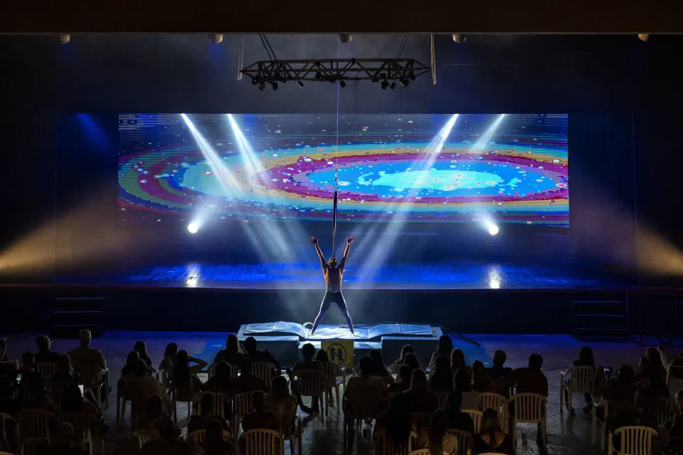 Performer on a lit stage with colorful LED backdrop at Viva Maya