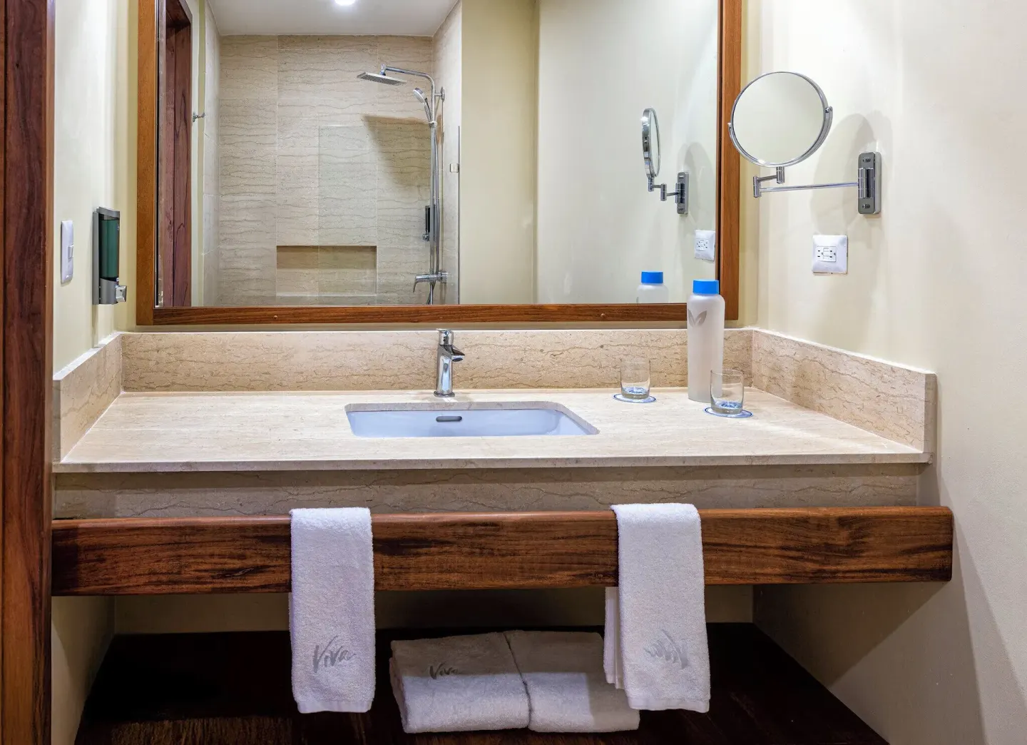 Splash Room bathroom vanity with sink, mirror, towels, and shower at Viva Miches.