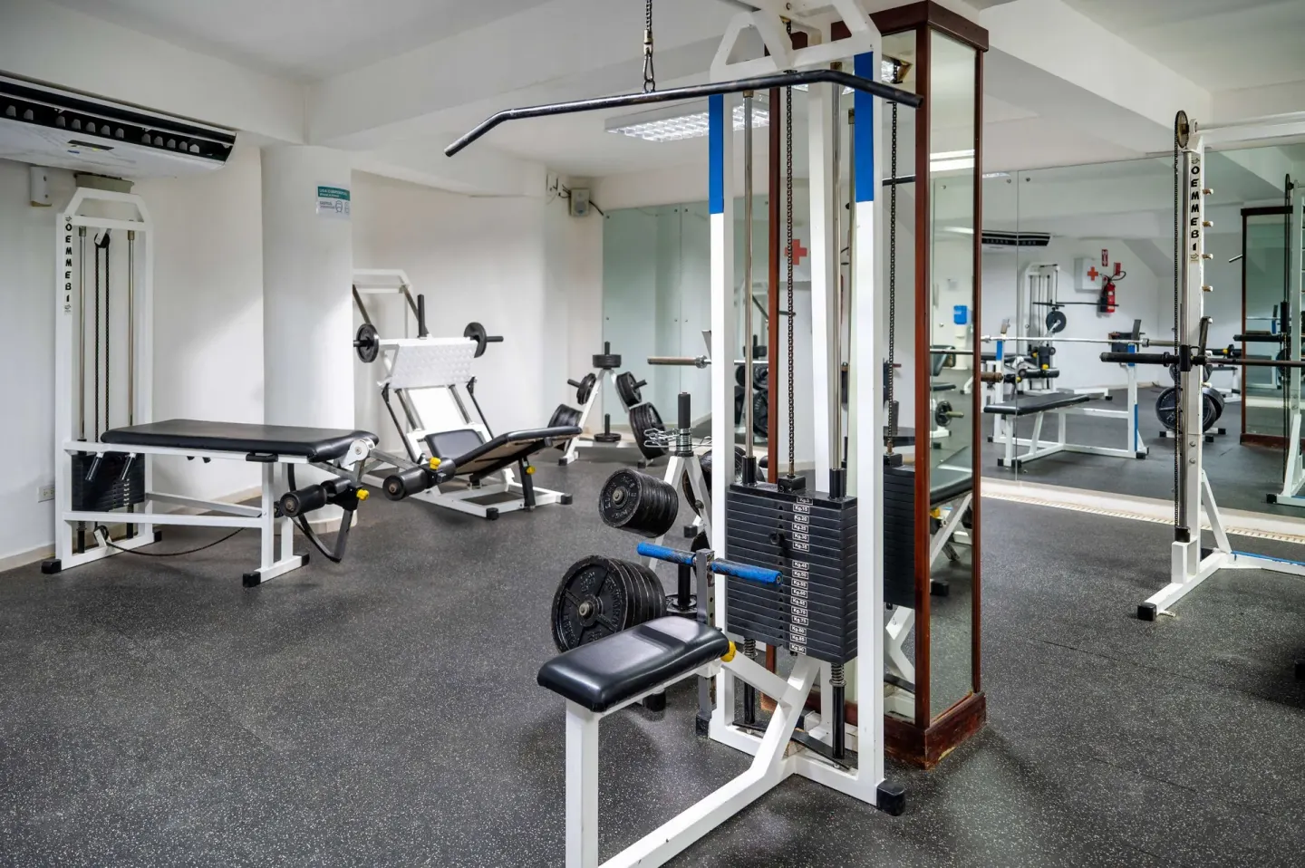Fitness room with weight machines, benches, mirrors, and rubber flooring at Viva Tangerine.