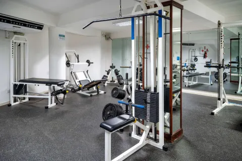 Fitness room with weight machines, benches, mirrors, and rubber flooring at Viva Tangerine.